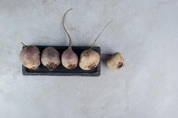 Whole fresh beetroots on a dark cutting board