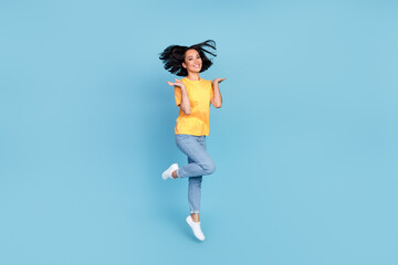 Full body portrait of overjoyed adorable lady jumping good mood isolated on blue color background