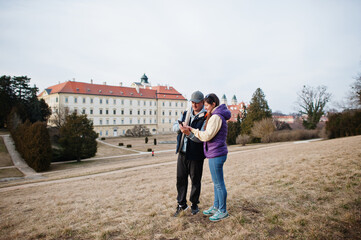 Obraz premium Couple tourist at Valtice palace look on mobile phone, Czech Republic.