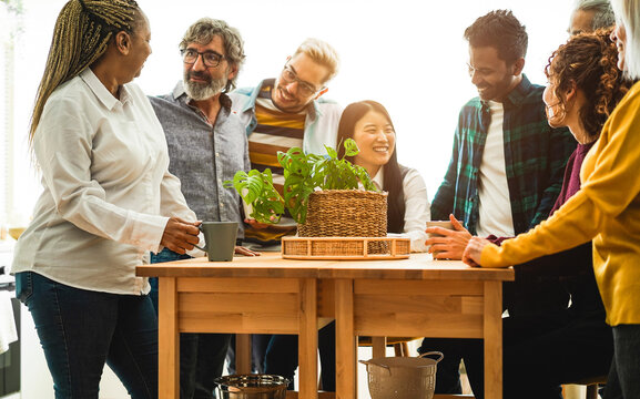 Multiracial happy friends having fun drinking coffee in the kitchen - Focus on senior african woman head