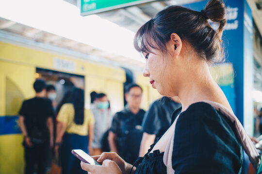 Beautiful asian woman use smartphone travel in city train