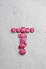 letter T outlined with pink flowers on a white background
