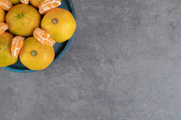 Delicious tangerines in a dark blue plate