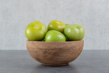 Fresh green tomatoes in wooden bowl