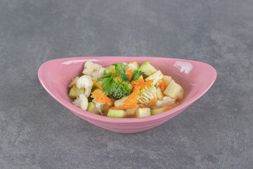 Slices of fresh vegetables in pink bowl