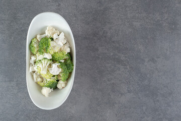 Sliced broccoli and cauliflower in white bowl