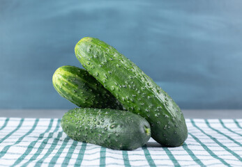 Three fresh cucumbers isolated on a tablecloth