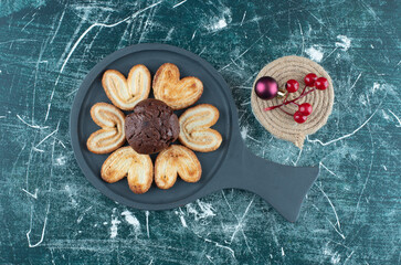 A dark board with chocolate muffin and cookies