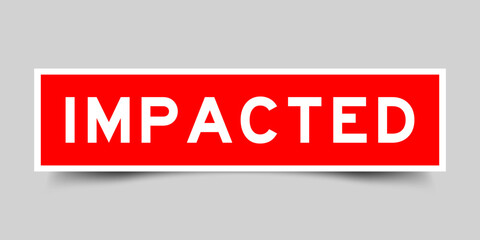 Sticker label with word impacted in red color on gray background