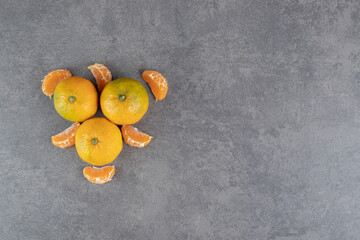 Ripe tangerines and segments on marble background