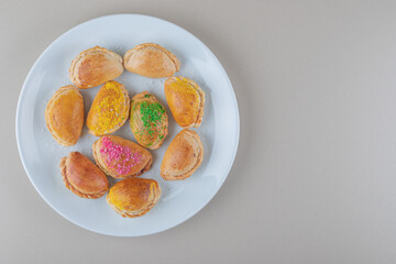 Serving of small buns on a white platter on marble background