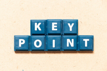 Tile letter in english word key point on wood background