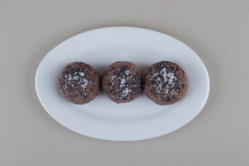 A serving of chocolate cookies on a platter on marble background
