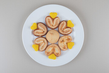 Dessert assortment with cookies and marmelades on a platter on marble background