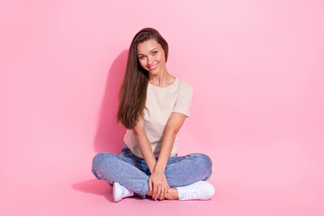 Full length photo of adorable satisfied person sit floor crossed legs isolated on pink color background