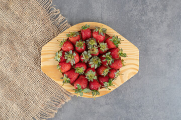 Bunch of red strawberries on wooden plate
