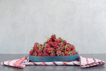 Delicious red raspberries on blue plate