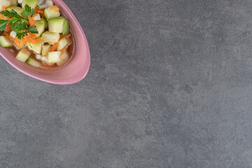 Slices of fresh vegetables in pink bowl