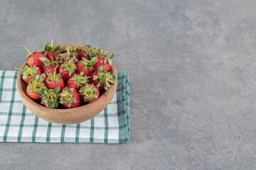 Bunch of fresh strawberries in wooden bowl
