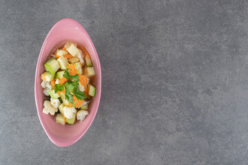 Slices of fresh vegetables in pink bowl