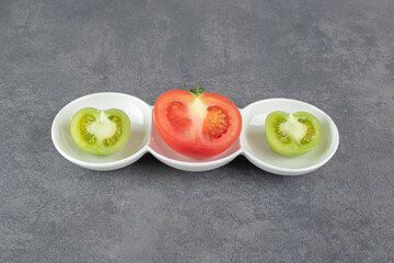 Sliced green and red tomatoes on white plate