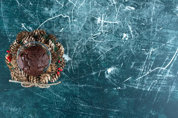 A glass plate with chocolate cookie and Christmas wreath