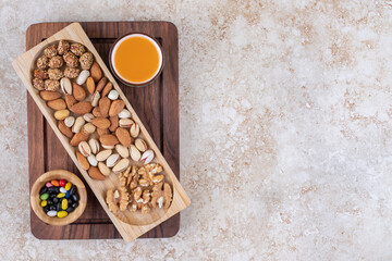 Bunch of nut kernels on wooden plate with hot tea