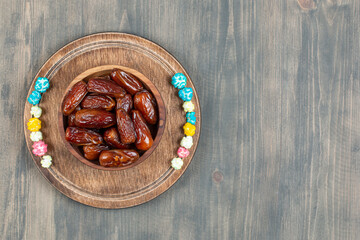 Bowl of dates and popcorns on wooden plate