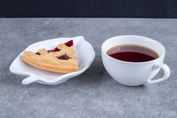 Slice of pie and cup of tea on marble background