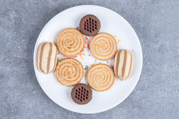 Various sweet biscuits on white plate