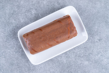 Chocolate roll cake on white plate