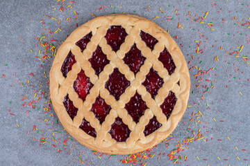 Delicious berry pie with sprinkles on marble background