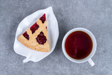 Slice of pie and cup of tea on marble background
