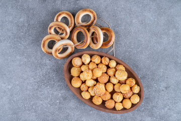 Round crackers and plate full of salty crackers on marble surface