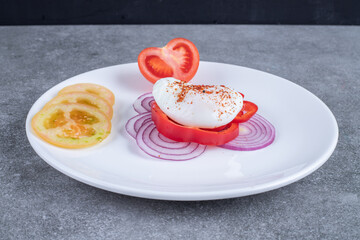 A white plate full of sliced vegetables and boiled egg