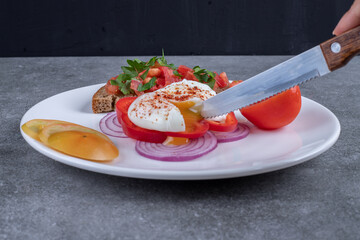 A white plate full of sliced vegetables and boiled egg