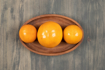 Delicious juicy persimmons on a wooden board