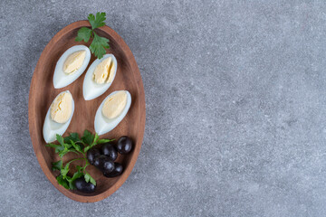 Fototapeta na wymiar A wooden board with olives and boiled eggs