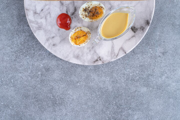 A marble plate with boiled egg and sauce