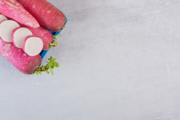 Raw red turnips on blue plate