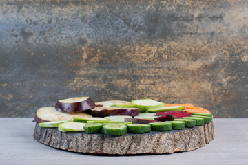 Fresh sliced raw vegetables on wooden piece