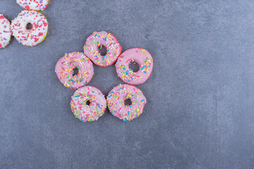 Colorful sweet fresh donuts on a gray background