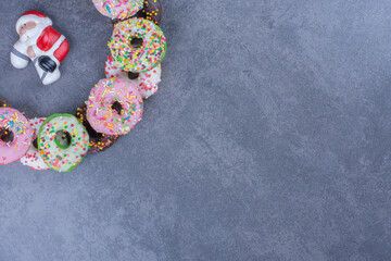Colorful sweet fresh donuts on a gray background