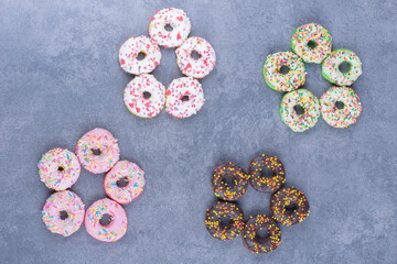 Colorful sweet fresh donuts on a gray background