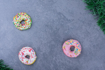 Colorful sweet fresh donuts on a gray background