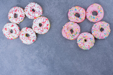Colorful sweet fresh donuts on a gray background