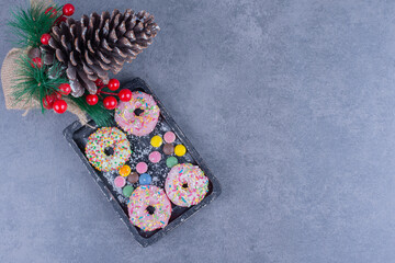 A dark board full of donuts with sweet jelly candies