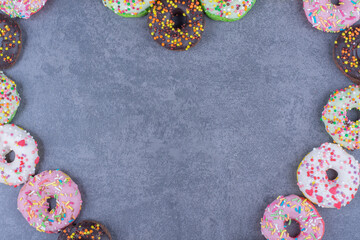 Colorful sweet fresh donuts on a gray background