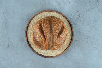 Delicious rye bun on wooden plate