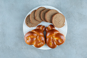 Sweet pastry and bread slices on white plate